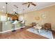 Open-concept room with kitchen, breakfast bar, and seating area with wood floors and neutral paint at 1221 Glendora N Rd, Kissimmee, FL 34759