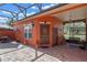 Cozy outdoor patio featuring brick pavers, a decorative iron gate, and outdoor seating with a lovely entry door at 1221 Glendora N Rd, Kissimmee, FL 34759