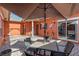 Inviting outdoor patio with comfortable seating, a shade umbrella, and serene view of the surrounding landscape at 1221 Glendora N Rd, Kissimmee, FL 34759