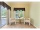 Bright Sunroom features tile floors, two chairs and natural light from a sliding glass door and window at 1221 Glendora N Rd, Kissimmee, FL 34759