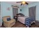 Comfortable bedroom featuring blue walls, wood floors, and a cozy chair at 1533 Findlay St, Deltona, FL 32725