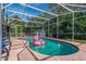 Sparkling screened pool surrounded by lush greenery and a clear blue sky at 1533 Findlay St, Deltona, FL 32725