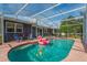 Screened pool with a flamingo float and seating, surrounded by a spacious patio area at 1533 Findlay St, Deltona, FL 32725