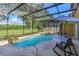 Inviting pool area with screened enclosure, patio furniture, and lush landscaping at 315 Aldridge Ln, Davenport, FL 33897