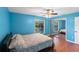 Bright bedroom with wood floors, ceiling fan, blue walls, and a mirrored closet at 3390 Cedar Spring Pl # 163, Winter Park, FL 32792
