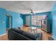 Bright living room with blue walls, a comfortable sofa, ceiling fan, and a large window for natural light at 3390 Cedar Spring Pl # 163, Winter Park, FL 32792