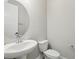 This half bathroom features a pedestal sink and a round mirror at 5015 Railroad Vine Aly, Winter Garden, FL 34787