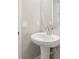 This half bathroom features a pedestal sink with classic faucet and a round mirror at 5015 Railroad Vine Aly, Winter Garden, FL 34787