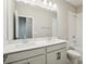 This bathroom features dual sinks with quartz countertops and tiled shower with a glass enclosure at 5015 Railroad Vine Aly, Winter Garden, FL 34787