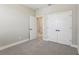 A bedroom featuring neutral walls and carpeted floors with a double closet and doorway at 5015 Railroad Vine Aly, Winter Garden, FL 34787
