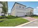 Charming two-story home with gray siding, a two-car garage, and manicured lawn at 5015 Railroad Vine Aly, Winter Garden, FL 34787