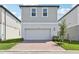 Charming two-story home featuring a gray exterior, a brick driveway, and an attached two-car garage at 5015 Railroad Vine Aly, Winter Garden, FL 34787