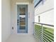 Welcoming covered front porch with a modern blue glass door and sleek metal railing at 5015 Railroad Vine Aly, Winter Garden, FL 34787