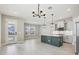 Open-concept kitchen with center island, modern pendant lighting, stainless steel appliances and ample space at 5015 Railroad Vine Aly, Winter Garden, FL 34787