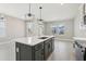 Spacious kitchen featuring a central island with breakfast bar, stainless steel appliances, and modern pendant lighting at 5015 Railroad Vine Aly, Winter Garden, FL 34787