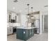 Modern kitchen features a large island with a dark green base, stainless steel appliances and pendant lighting at 5015 Railroad Vine Aly, Winter Garden, FL 34787