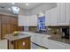 Well-equipped kitchen with granite countertops, white cabinets, and a convenient island with fruit basket at 8407 River Branch Pl, Sanford, FL 32771