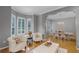 Bright living room with bay windows, hardwood floors, comfortable seating, and view into the dining room at 8407 River Branch Pl, Sanford, FL 32771