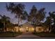 Inviting home featuring arched windows, a well-manicured lawn, mature trees, and a tile roof at 8681 Crested Eagle Pl, Sanford, FL 32771