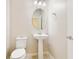 Bathroom features a pedestal sink, decorative mirror, and a neutral color palette at 3303 Kayak Way, Orlando, FL 32820
