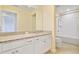 This bathroom features a sink, white cabinetry, a granite countertop, and a shower with a tub at 3303 Kayak Way, Orlando, FL 32820