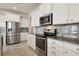 Bright kitchen features stainless steel appliances, white cabinets, granite countertops, and mosaic tile backsplash at 3303 Kayak Way, Orlando, FL 32820