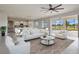 Living room featuring white furniture, modern ceiling fan, large windows to the outside, and an open view to the kitchen at 3303 Kayak Way, Orlando, FL 32820
