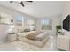 Spacious main bedroom with neutral tones, carpeted floor, large windows, modern lamps, and a TV at 3303 Kayak Way, Orlando, FL 32820