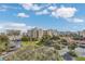 Expansive view of the community with lush landscaping, a pool, and surrounding buildings under a bright sky at 5300 S Atlantic Ave # 6-501, New Smyrna Beach, FL 32169