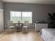 Bedroom featuring a large window, neutral gray walls, and seating, filling the room with natural light at 5300 S Atlantic Ave # 6-501, New Smyrna Beach, FL 32169