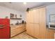 Small galley kitchen with red refrigerator and wooden cabinets at 733 Clifford Dr, Orlando, FL 32804