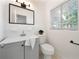 Clean bathroom with gray vanity, white tile, and window at 924 Beard Ave, Winter Park, FL 32789