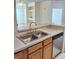 A kitchen featuring a double sink, stainless steel dishwasher, and light wood cabinets at 13103 Mulberry Park Dr # 817, Orlando, FL 32821