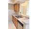 Kitchen featuring a double sink, stainless steel dishwasher, and light wood cabinets at 13103 Mulberry Park Dr # 817, Orlando, FL 32821