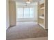 Well-lit living room featuring a large window and built-in shelves, carpeted for comfort at 13103 Mulberry Park Dr # 817, Orlando, FL 32821