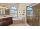 Bathroom featuring a soaking tub, glass enclosed shower, and dark wood vanity with marble countertop at 2801 Ripton Ct, Orlando, FL 32835