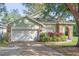Charming single-story home with a two-car garage, arched entryway, and landscaped garden at 2801 Ripton Ct, Orlando, FL 32835