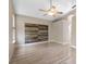 Living Room featuring wood look tiling, ceiling fan, and an accent wall made of reclaimed wood at 2801 Ripton Ct, Orlando, FL 32835