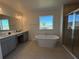 Luxurious bathroom with soaking tub, double vanity, and walk-in shower at 6635 Tempo Way, Mascotte, FL 34753