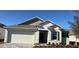 New single-story home with a two-car garage and landscaping at 6635 Tempo Way, Mascotte, FL 34753