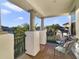 View from beautiful columned balcony showcasing chairs, iron railing and lush landscaping at 16659 Broadwater Ave, Winter Garden, FL 34787