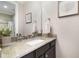 Close up on a granite countertop, a white porcelain sink, and a mirror above in a bathroom at 16659 Broadwater Ave, Winter Garden, FL 34787