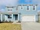 Two-story light blue house with a two-car garage and landscaped lawn at 5096 Tana Ter, St Cloud, FL 34773