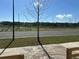 Scenic street view showcasing a tree-lined road and a tranquil pond in the background, under a clear blue sky at 5318 Center Lake Ranch Blvd, Saint Cloud, FL 34771