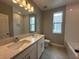 Well-lit bathroom featuring double sinks, a large mirror, and a shower-tub combination with tiled walls at 5318 Center Lake Ranch Blvd, St Cloud, FL 34771