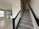 Carpeted stairs with a black and white banister lead to the upper level of this beautifully designed home at 5318 Center Lake Ranch Blvd, St Cloud, FL 34771