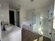 Modern bathroom with double sinks, a soaking tub, and a glass-enclosed shower at 5379 Park Guell St, St Cloud, FL 34771