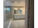 Modern bathroom featuring dual sinks, large mirrors, and a glass-enclosed shower at 5385 Park Guell St, St Cloud, FL 34771