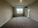Bedroom with carpet, a window overlooking the backyard, and a tray ceiling at 5385 Park Guell St, St Cloud, FL 34771