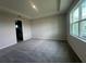 A carpeted bedroom with tray ceiling and large windows, offering natural light and a neutral color palette at 5385 Park Guell St, St Cloud, FL 34771